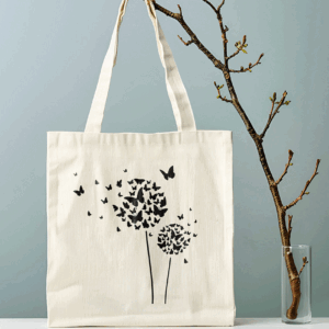Borsa shopper in cotone colore natural con stampa nera di soffioni e farfalle e manici lunghi a spalla.